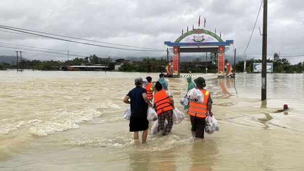 Người dân băng qua dòng lũ đem lương thực về nhà tiếp tế cho gia đình - Sputnik Việt Nam