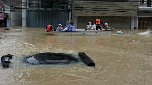 Đội cứu hộ Thái Lan bơi ngang qua một chiếc ôtô trong đợt lũ lụt ở tỉnh Songkhla, miền Nam Thái Lan - Sputnik Việt Nam