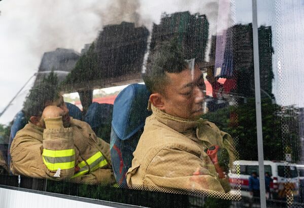 Lính cứu hỏa nghỉ ngơi trong khi chuyển ca tại khu phức hợp nhà ở &quot;Vạn Phúc Court&quot; ở Hồng Kông&quot; - Sputnik Việt Nam