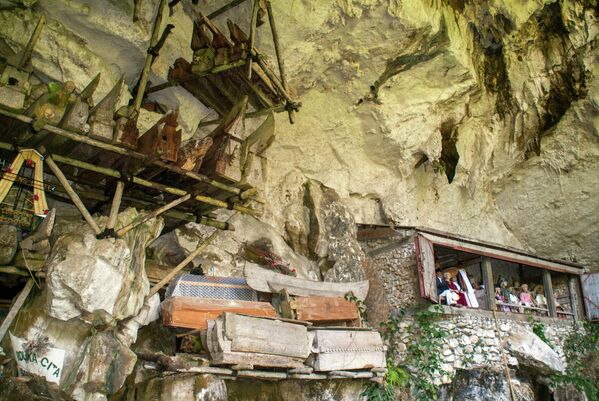 Quan tài treo và ban công với những bức tượng gỗ mô tả người đã khuất được gọi là tau-tau, trong một hang mộ ở Londa, Tana Toraja, Sulawesi, Indonesia - Sputnik Việt Nam