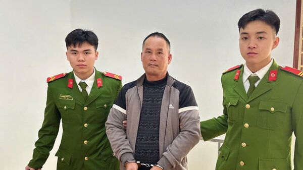 Đối tượng Đoàn Văn Sáng (áo xám) tại Cơ quan Công an. - Sputnik Việt Nam