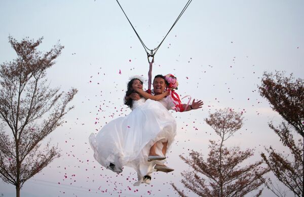 Các cặp đôi kỷ niệm Lễ hội Tình nhân bằng cách bay lên bầu trời trên "tàu lượn siêu tốc trên không" trong khuôn khổ lễ cưới mạo hiểm tại tỉnh Ratchaburi, Thái Lan - Sputnik Việt Nam