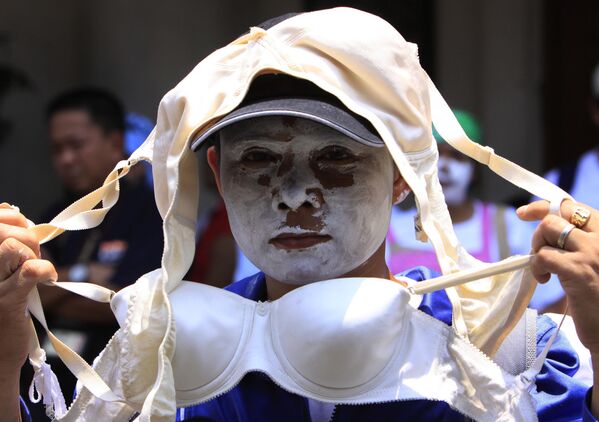 Nữ công nhân với khuôn mặt sơn trắng phô trương áo lót nữ trong cuộc biểu tình trước trụ sở Bộ Lao động vào thứ Ba tại Manila, Philippines - Sputnik Việt Nam