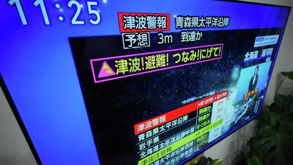 Cảnh báo sóng thần xuất hiện trên màn hình tivi ở Yokohama, Nhật Bản, ngày 8 tháng 12 năm 2025. - Sputnik Việt Nam