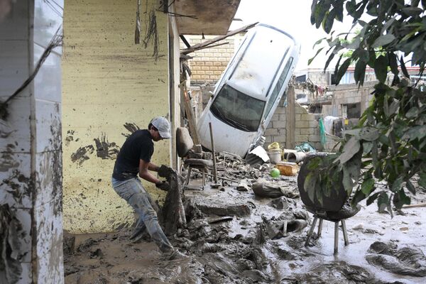 Người đàn ông dọn bùn đất tại khu vực bị ảnh hưởng bởi mưa lớn kéo dài ở Posa Rica, bang Veracruz, Mexico, ngày 13 tháng 10 năm 2025 - Sputnik Việt Nam