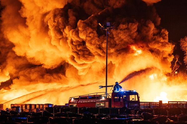 Lính cứu hỏa dập tắt đám cháy tại cơ sở tái chế nhựa trong khu công nghiệp ở Ahlen, Đức, ngày 10 tháng 4 năm 2025 - Sputnik Việt Nam