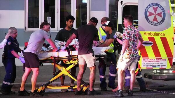 Lực lượng cứu hộ khẩn cấp đưa một người đàn ông bị thương trong vụ xả súng tại bãi biển Bondi ở Sydney đi cấp cứu - Sputnik Việt Nam