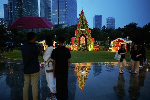 Khách bộ hành đi ngang qua cây thông Giáng sinh được dựng trong công viên ở Jakarta, Indonesia - Sputnik Việt Nam