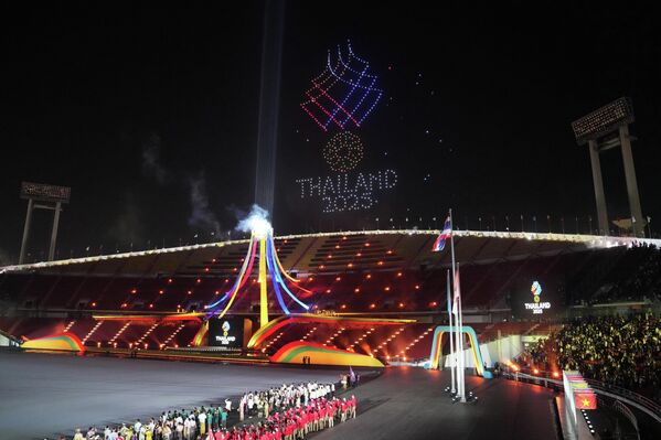 Khán giả theo dõi màn trình diễn ánh sáng bằng máy bay không người lái (drone) trong lễ khai mạc SEA Games 33 tại Bangkok, Thái Lan - Sputnik Việt Nam