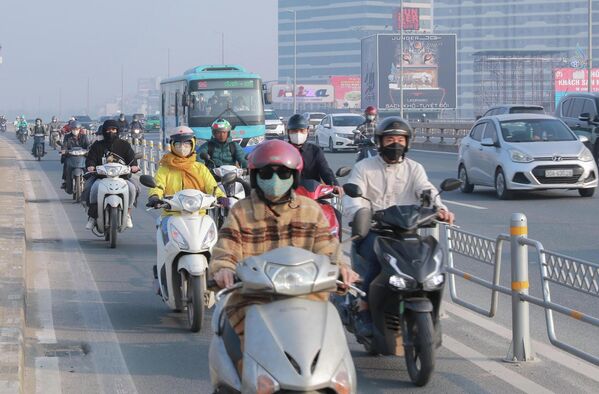 Người dân đeo khẩu trang khi lưu thông trên đường phố Hà Nội sáng 10/12/2025 để bảo vệ sức khoẻ.Tình trạng ô nhiễm không khí nghiêm trọng ở Hà Nội. Thành phố có kế hoạch hạn chế xe xăng và tăng cường phương tiện chuyển đổi sang xe điện. - Sputnik Việt Nam