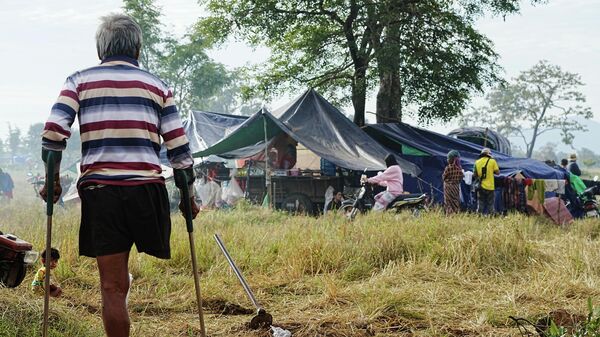Một người sơ tán nhìn về phía những túp lều của người thân mình, những người đã tìm được nơi trú ẩn trong một cánh đồng lúa ở Chong Kal, Campuchia - Sputnik Việt Nam
