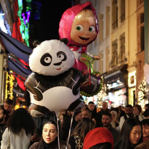 Cô gái cầm những quả bóng in hình gấu trúc và nhân vật trong phim hoạt hình “Masha và Gấu” tại Brussels - Sputnik Việt Nam