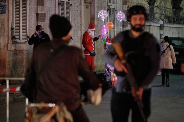 Người đàn ông mặc đồ ông già Noel bán đồ trang trí Giáng sinh tại khu phố chủ yếu theo đạo Cơ Đốc ở Kassa, Damas, Syria - Sputnik Việt Nam