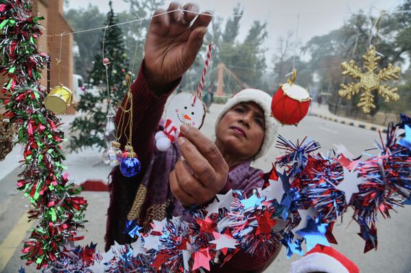 Người phụ nữ treo đồ trang trí Giáng sinh trong Nhà thờ Thánh Gioan ở Peshawar, Pakistan - Sputnik Việt Nam