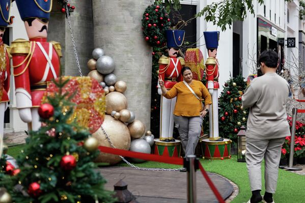 Du khách chụp ảnh lưu niệm bên những trang trí Giáng sinh rực rỡ trong trung tâm thương mại PVJ ở Bandung, Tây Java, Indonesia - Sputnik Việt Nam