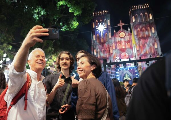 Du khách nước ngoài ghi lại khoảnh khắc chờ đón Giáng sinh 2025 tại quảng trường trước Nhà thờ Lớn - Sputnik Việt Nam