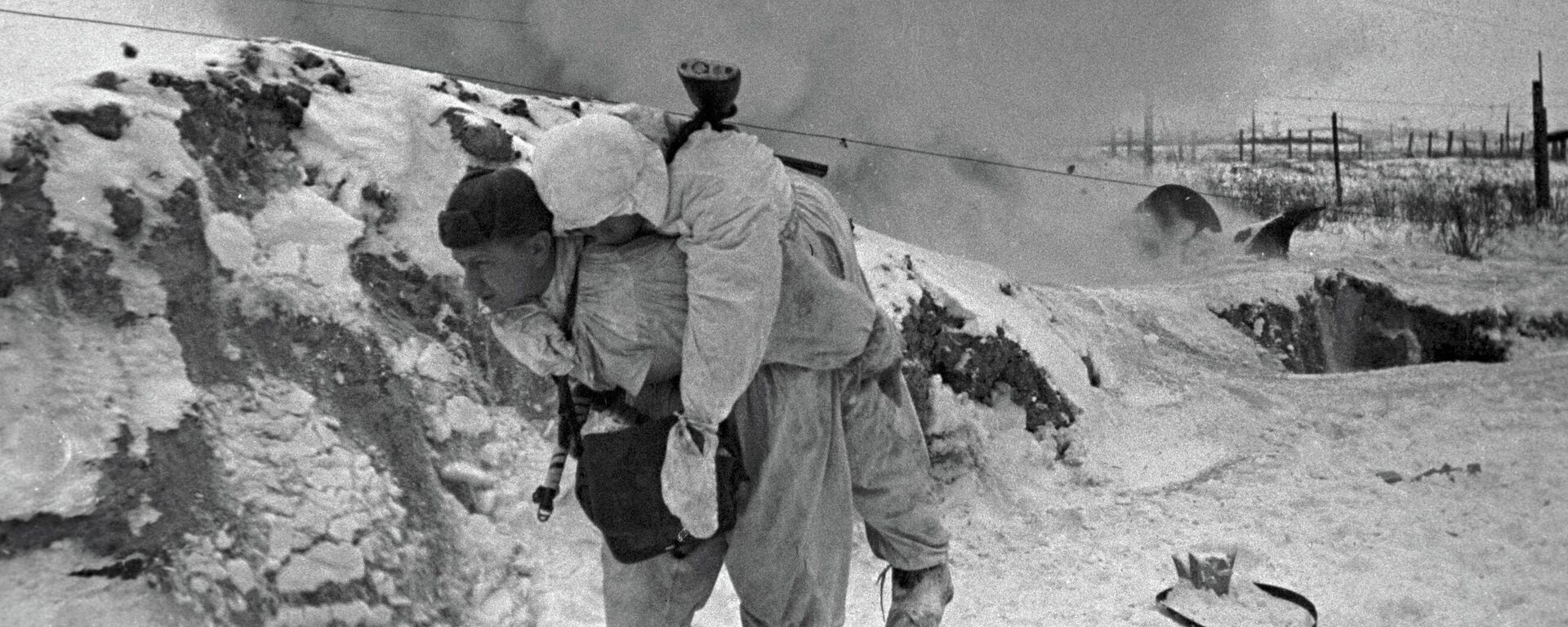 Một nhân viên y tế Liên Xô cõng chiến sĩ bị thương rời khỏi chiến trường trong trận chiến ở ngoại vi Leningrad - Sputnik Việt Nam, 1920, 18.01.2026
