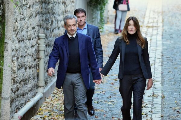 Cựu Tổng thống Pháp Nicolas Sarkozy cùng vợ là Carla Bruni-Sarkozy bước lên xe để đến nhà tù, nơi ông bắt đầu chấp hành bản án 5 năm tù, ngày 21 tháng 10 năm 2025 - Sputnik Việt Nam