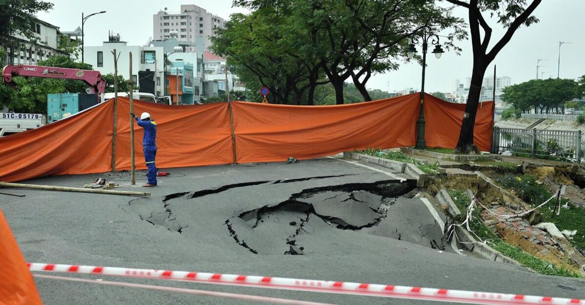 Lực lượng chức năng phong tỏa khẩn cấp, quây bạt và đặt biển báo hố sâu nguy hiểm để cảnh báo người dân - Sputnik Việt Nam, 1920, 18.01.2026