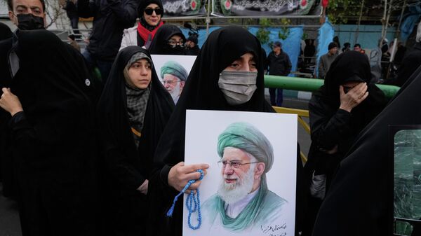 Женщина держит плакат с изображением верховного лидера Ирана Аятоллы Али Хаменеи во время похоронной церемонии в Тегеране, Иран - Sputnik Việt Nam