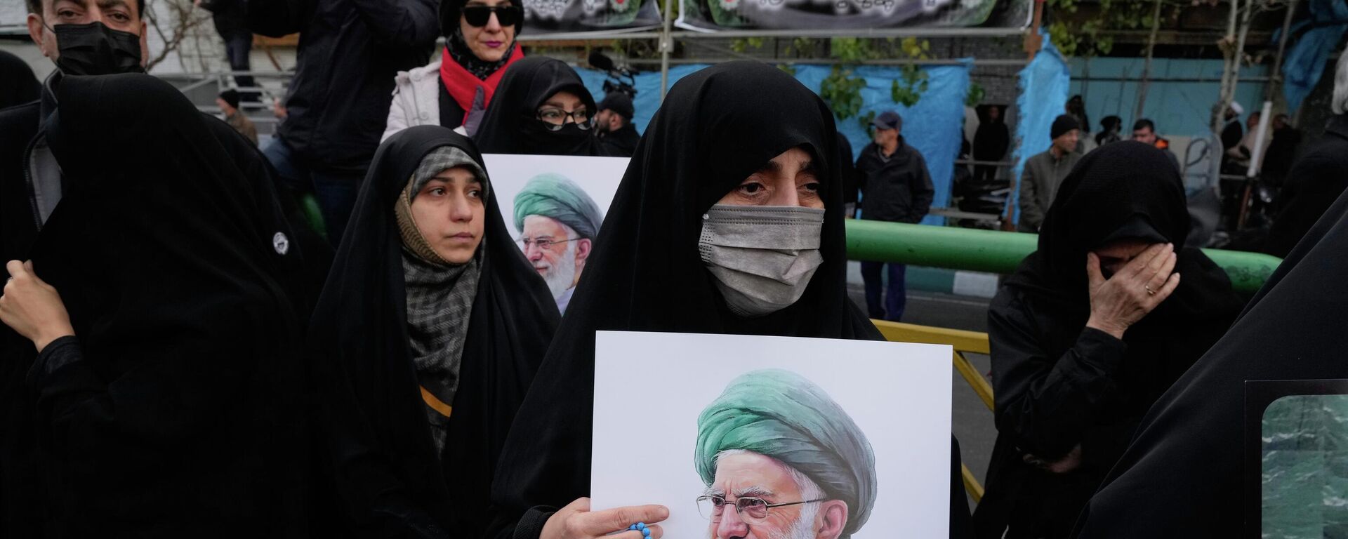 Một người phụ nữ cầm tấm áp phích của Lãnh tụ tối cao Iran, Ayatollah Ali Khamenei, trong một lễ tang ở Tehran, Iran. - Sputnik Việt Nam, 1920, 01.03.2026