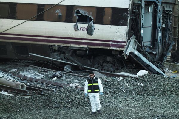 Nhân viên của Lực lượng Dân vệ Tây Ban Nha đứng cạnh đống đổ nát tại hiện trường vụ trật bánh hai đoàn tàu cao tốc ngày 20 tháng Một năm 2026 gần Adamos, Tây Ban Nha - Sputnik Việt Nam