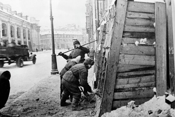 Sau khi cuộc bao vây Leningrad được dỡ bỏ, người dân thành phố tháo dỡ các hầm trú ẩn khỏi các ngôi nhà trên phố Sadovaya. Tòa nhà Gostiny Dvor nằm bên trái - Sputnik Việt Nam