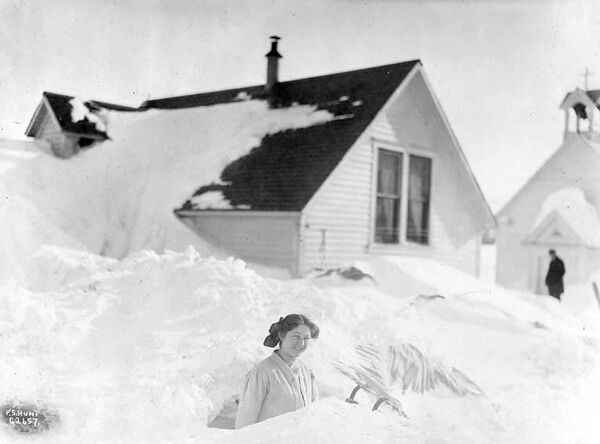 Một phụ nữ lội qua đống tuyết chất cao sau trận bão tuyết tại Valdez, Alaska. - Sputnik Việt Nam