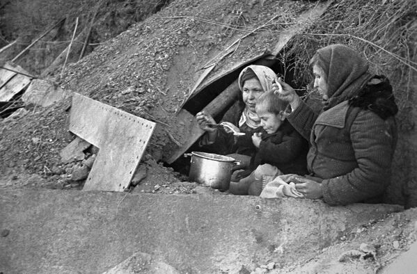 Những cư dân thành phố mất hết sản nghiệp tại lối vào một căn hầm trú ẩn được cải tạo thành nhà ở - Sputnik Việt Nam