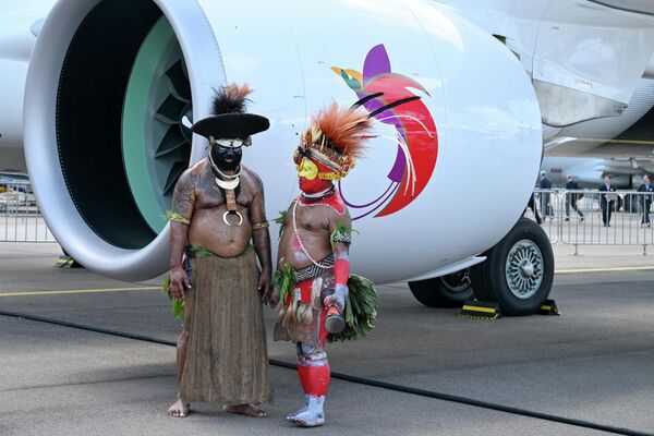 Các vũ công đến từ Papua New Guinea đứng cạnh máy bay Air Níugini trước khi biểu diễn tại Trung tâm Hội nghị và Triển lãm Changi, Singapore - Sputnik Việt Nam