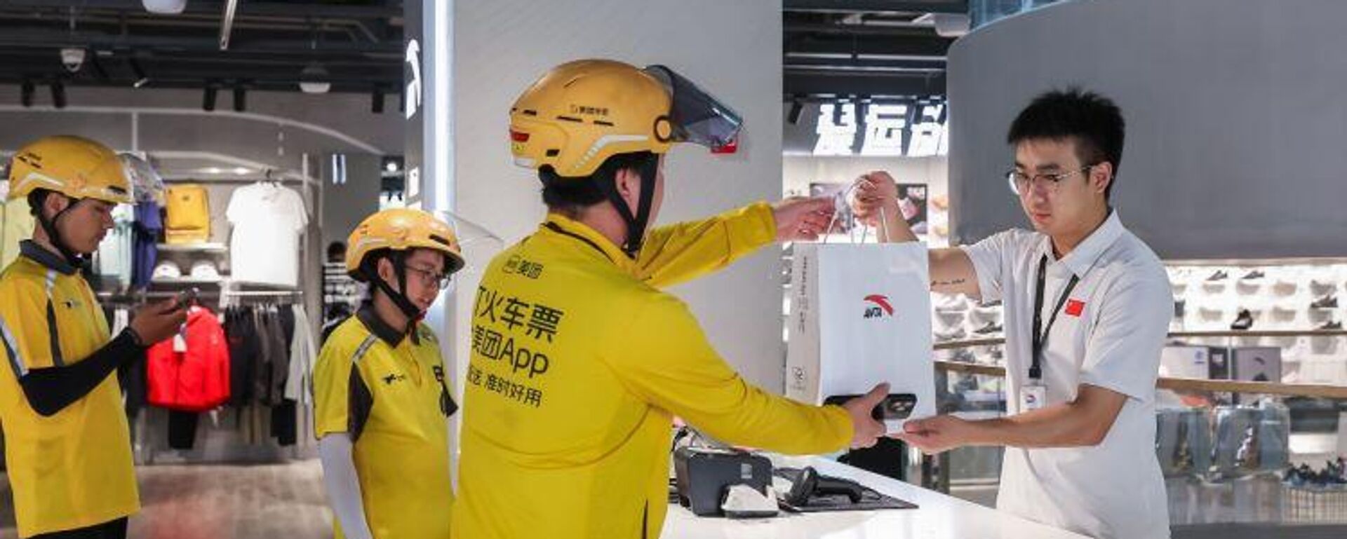 Một nhân viên giao hàng của Meituan nhận đơn hàng từ cửa hàng. - Sputnik Việt Nam, 1920, 12.02.2026