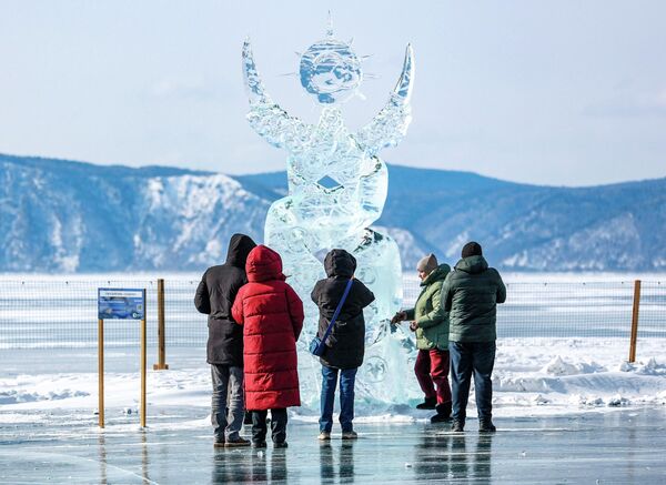 Những người tham gia Lễ hội nghệ thuật băng giá mùa đông lần thứ XII "Sống trên Baikal" 2026 bên tác phẩm điêu khắc "Hoàng đạo" - Sputnik Việt Nam