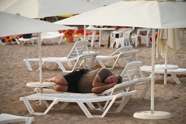 Người đàn ông ngủ trên ghế dài ở bãi biển tại Gelendzhik (Nga) - Sputnik Việt Nam