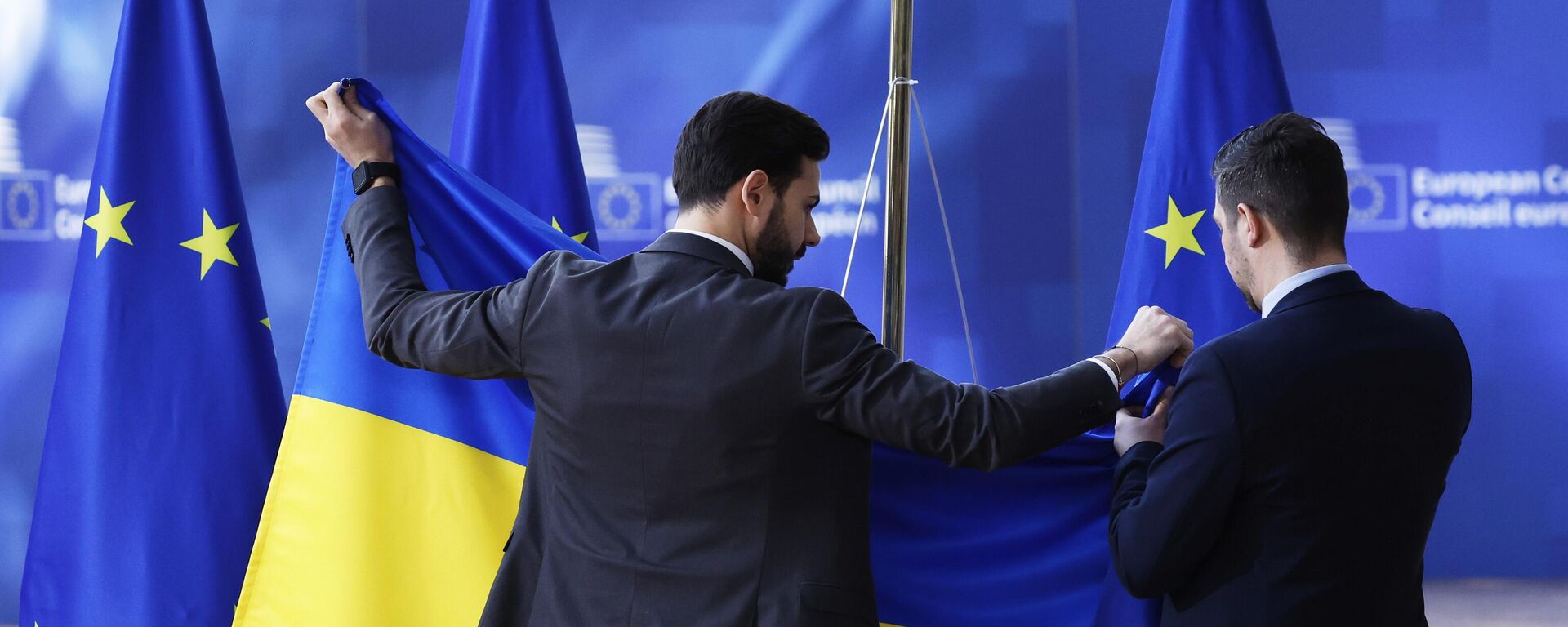 Các nhân viên lễ tân treo cờ Ukraina trước khi Vladimir Zelensky đến - Sputnik Việt Nam, 1920, 15.04.2026