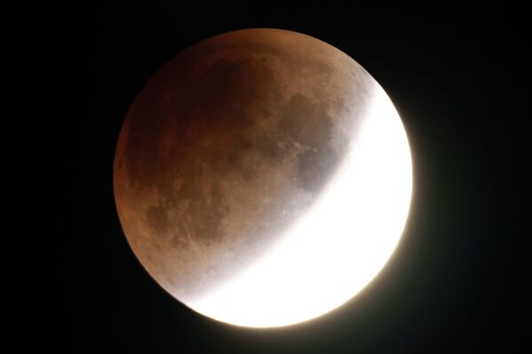 Trăng giun máu phát sáng màu cam khi nó tiến gần đến toàn phần vào sáng sớm, gần thành phố Moscow, Idaho, Hoa Kỳ - Sputnik Việt Nam