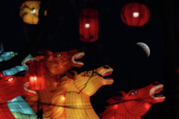 Mặt trăng có thể nhìn thấy ngay trước khi toàn phần xảy ra ngay bên những chiếc đèn lồng hình ngựa ở Bắc Kinh, Trung Quốc - Sputnik Việt Nam