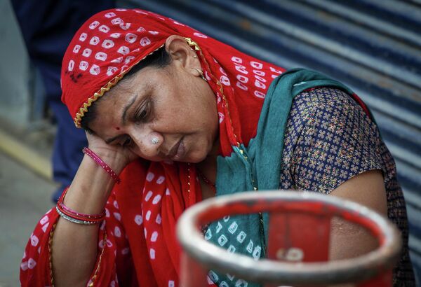 Một người phụ nữ ngồi cạnh bình khí hóa lỏng đã hết, Ấn Độ - Sputnik Việt Nam