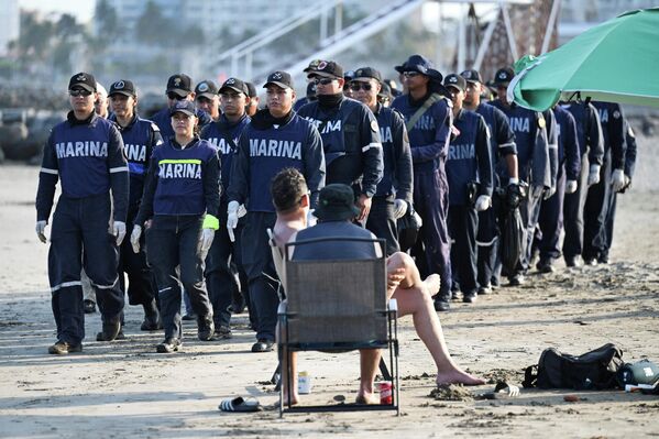 Du khách theo dõi lực lượng quân đội tiến hành tìm kiếm các mảng nhựa đường trên Bãi biển Caracol, một tháng sau khi những dấu hiệu ô nhiễm đầu tiên được phát hiện tại các bang Veracruz và Tabasco, Mexico. Du khách theo dõi lực lượng quân đội tiến hành tìm kiếm các mảng nhựa đường trên Bãi biển Caracol, một tháng sau khi những dấu hiệu ô nhiễm đầu tiên được phát hiện tại các bang Veracruz và Tabasco, Mexico. - Sputnik Việt Nam