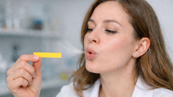 Một cô gái thổi vào giấy quỳ. - Sputnik Việt Nam