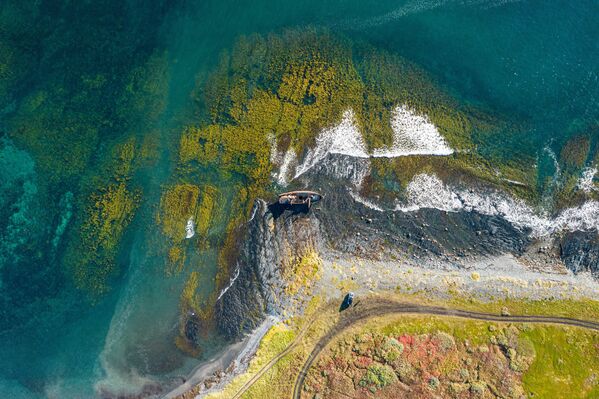 Chiếc thuyền đánh cá bị bão xô dạt vào bờ tại Mũi Nemetsky, trên bán đảo Rybachy ở vùng Murmansk của Nga. - Sputnik Việt Nam