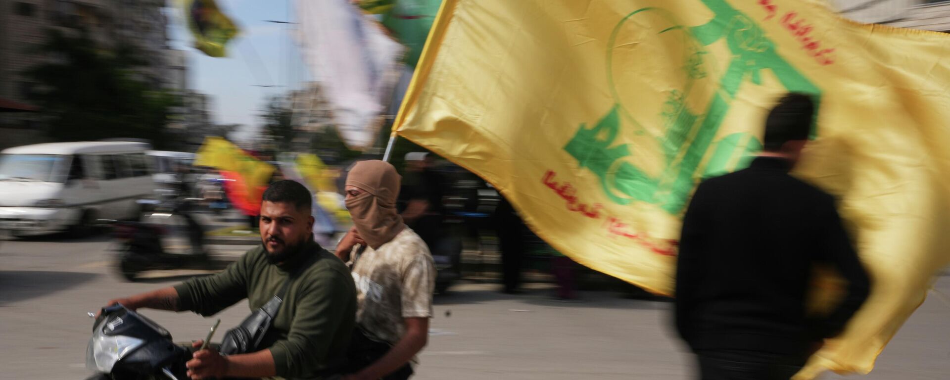 Đàn ông lái xe máy lấy lá cờ Hezbollah trong khi cuộc họp nhỏ tại Dahiyeh, ngoại ô nam Beirut, Lebanon, ngày thứ bảy, 25, tháng tư, năm 2026 - Sputnik Việt Nam, 1920, 02.06.2026