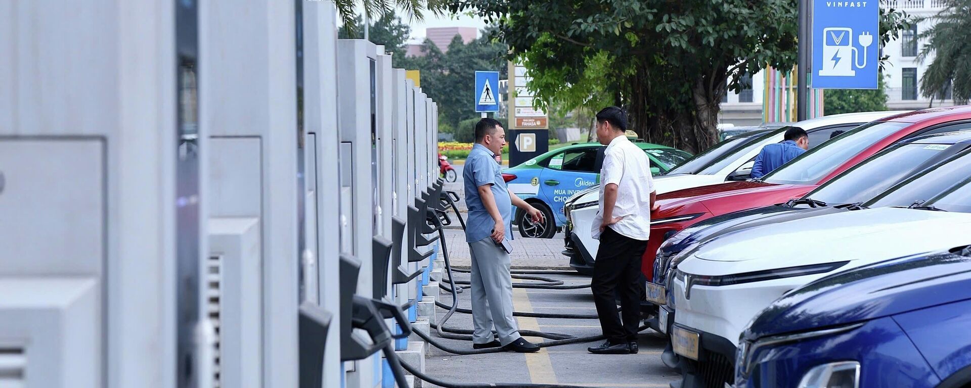 Người dân sử dụng trạm sạc để nạp điện cho phương tiện tại khu đô thị phía Tây Hà Nội, cho thấy nhu cầu sử dụng năng lượng xanh ngày càng tăng - Sputnik Việt Nam, 1920, 29.04.2026