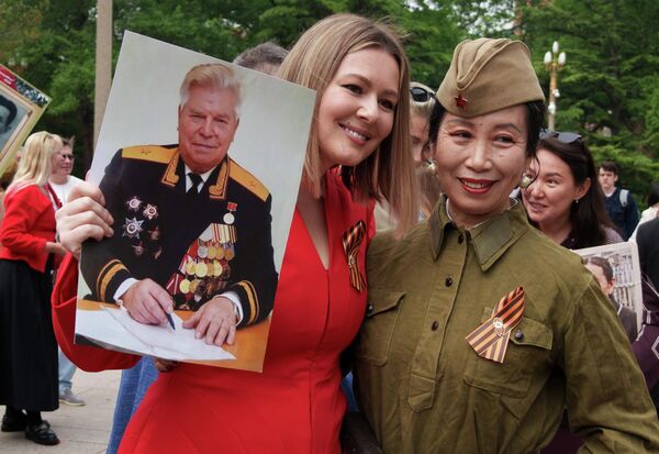 Nữ nghệ sĩ Nga Maria Kozhevnikova (đứng bên trái ở phần trung tâm) trong cuộc diễu hành "Trung đoàn Bất tử" ở Bắc Kinh kỷ niệm 81 năm Ngày Chiến thắng trong Chiến tranh Vệ quốc vĩ đại - Sputnik Việt Nam