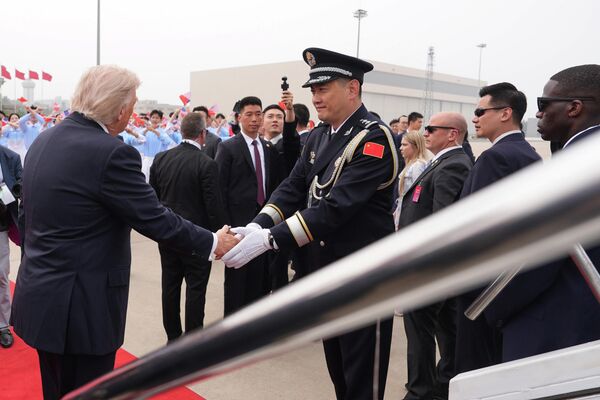 Tổng thống Donald Trump bắt tay quan chức Trung Quốc trước khi lên chuyên cơ Air Force One. - Sputnik Việt Nam