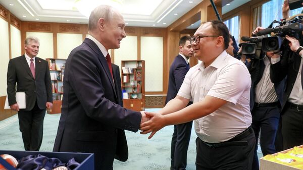 Tổng thống Nga Vladimir Putin và kỹ sư người Trung Quốc Bành Phái trong một cuộc gặp tại Đại lễ đường Nhân dân ở Bắc Kinh. - Sputnik Việt Nam