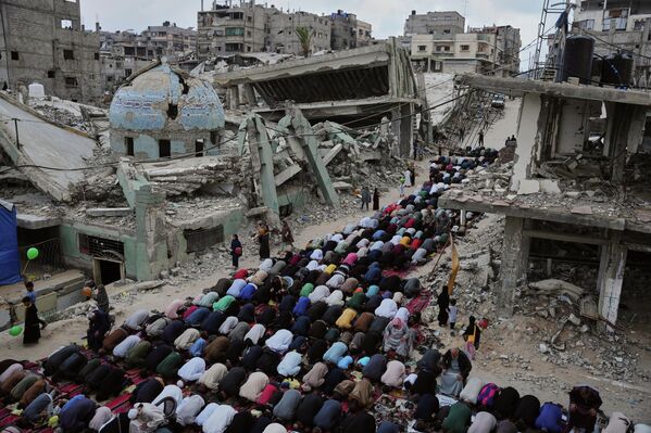 Người Palestine làm lễ cầu nguyện Eid al-Adha bên cạnh tàn tích của một nhà thờ Hồi giáo bị bom Israel phá hủy, Palestine. - Sputnik Việt Nam
