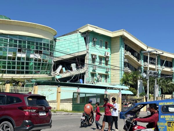 Mọi người di chuyển xung quanh các tòa nhà bị hư hại sau trận động đất mạnh 7,8 độ richter ở General Santos, Mindanao, Philippines. - Sputnik Việt Nam