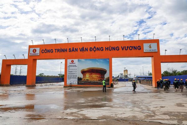 Các công nhân đi bộ gần lối vào Sân vận động Hùng Vương đang xây dựng. - Sputnik Việt Nam