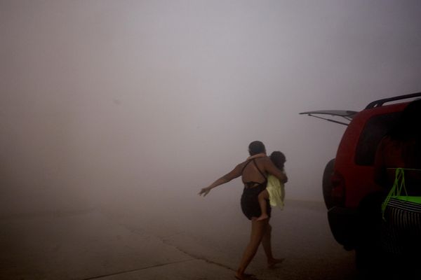 Người phụ nữ chạy cùng trẻ em vào nơi trú ẩn trong trận động đất ở La Guaira, Venezuela. - Sputnik Việt Nam