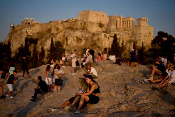 Du khách dùng quạt giải nhiệt trong đợt nắng nóng tại đồi Areopagus, với Acropolis ở phía sau, ở Athens (Hy Lạp). - Sputnik Việt Nam